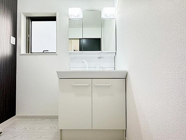 洗面台には三面鏡を採用。鏡の後ろに収納スペースが設けられています。