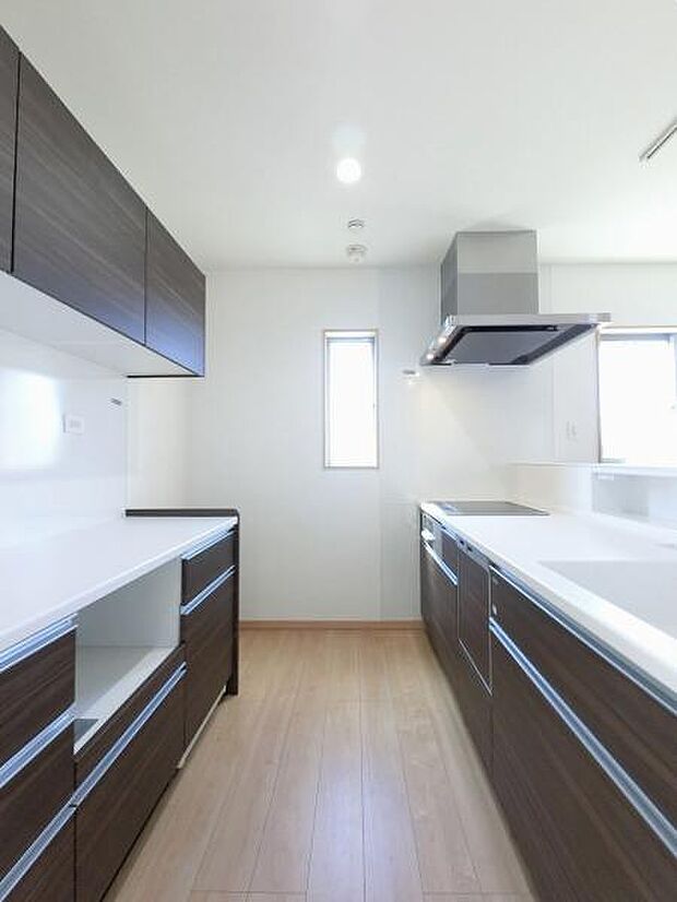 キッチン背面にキッチンと同色の面材を使用したカップボードを設置し、収納力と統一感を高めています。