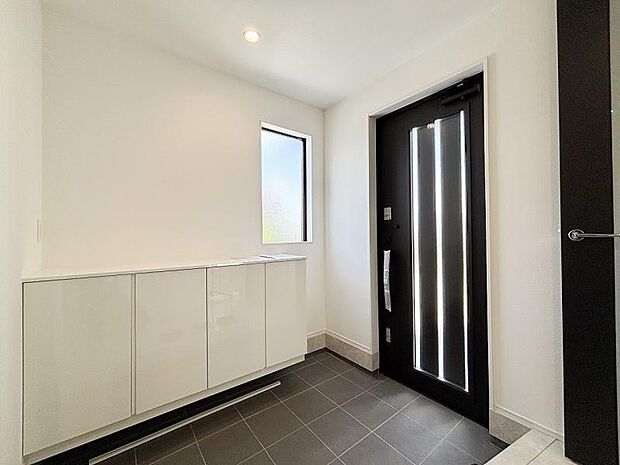 明るくコントラストのある、開放感と清潔感を兼ね備えた玄関。