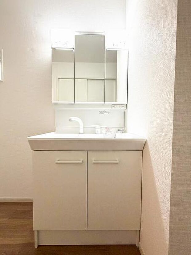 洗面化粧台には三面鏡を採用。鏡の後ろに収納スペースが設けられています。