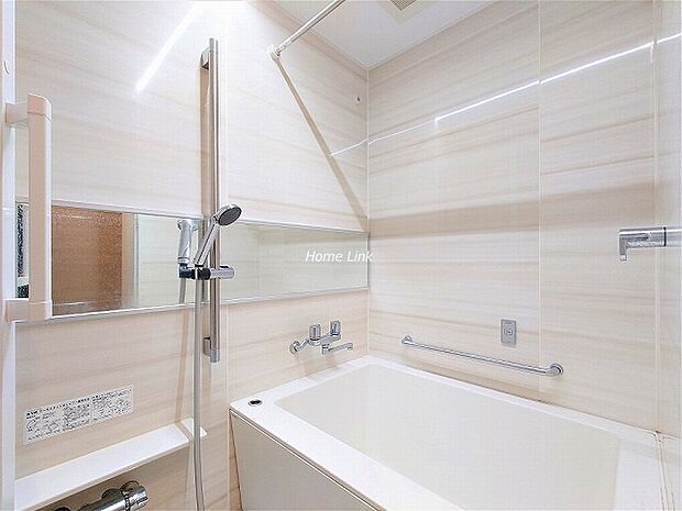 手すり付きで安心のバスルームです。横に長い鏡が、浴室内をより広く感じさせます。