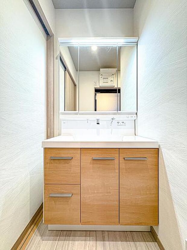 【収納豊富な三面鏡洗面台】左右の鏡を開いて三面鏡としても使える大型の鏡を設置。鏡の裏には、洗面用具などを機能的に収納できるスペースを設けています。