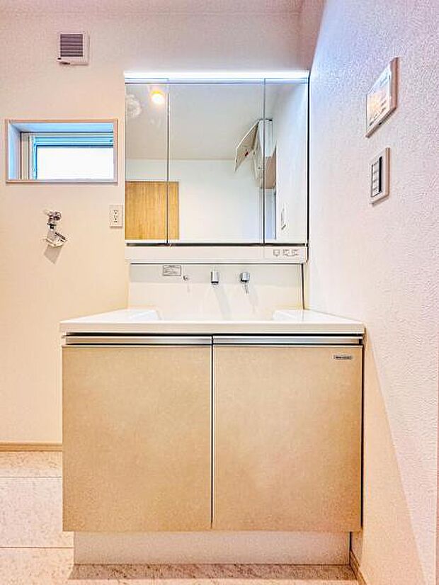 【収納豊富な三面鏡洗面台】左右の鏡を開いて三面鏡としても使える大型の鏡を設置。鏡の裏には、洗面用具などを機能的に収納できるスペースを設けています。