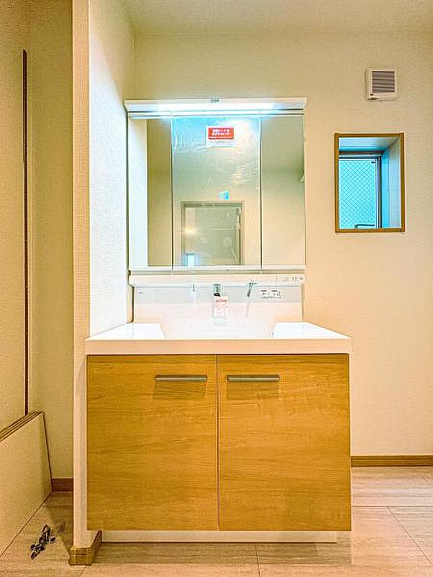 【嬉しい収納豊富な三面鏡洗面台】左右の鏡を開いて三面鏡としても使える大型の鏡を設置。鏡の裏には、洗面用具などを機能的に収納できるスペースを設けています。