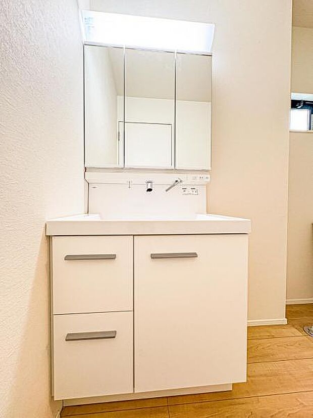 【嬉しい収納豊富な三面鏡洗面台】左右の鏡を開いて三面鏡としても使える大型の鏡を設置。鏡の裏には、洗面用具などを機能的に収納できるスペースを設けています。