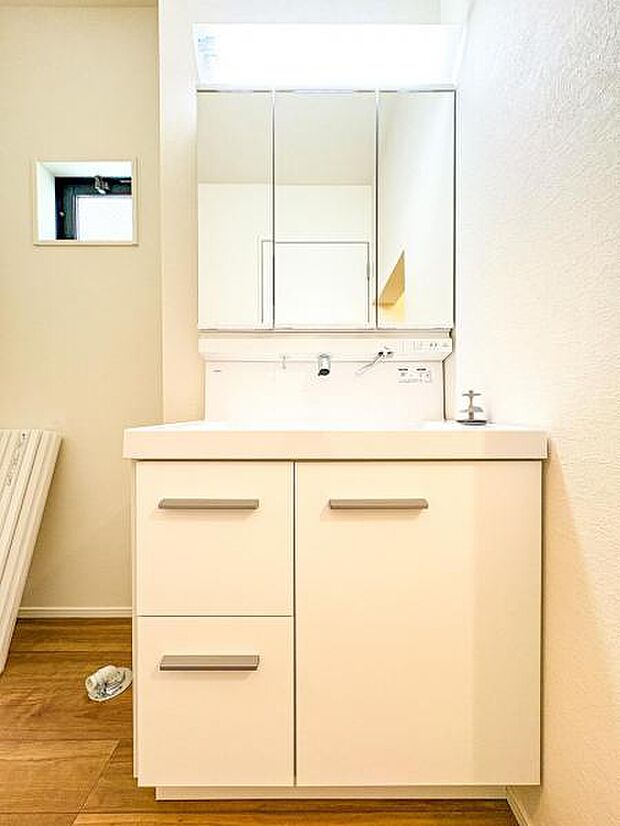 【嬉しい収納豊富な三面鏡洗面台】左右の鏡を開いて三面鏡としても使える大型の鏡を設置。鏡の裏には、洗面用具などを機能的に収納できるスペースを設けています。