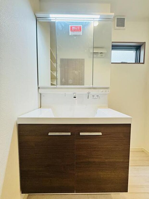 【嬉しい収納豊富な三面鏡洗面台】左右の鏡を開いて三面鏡としても使える大型の鏡を設置。鏡の裏には、洗面用具などを機能的に収納できるスペースを設けています。