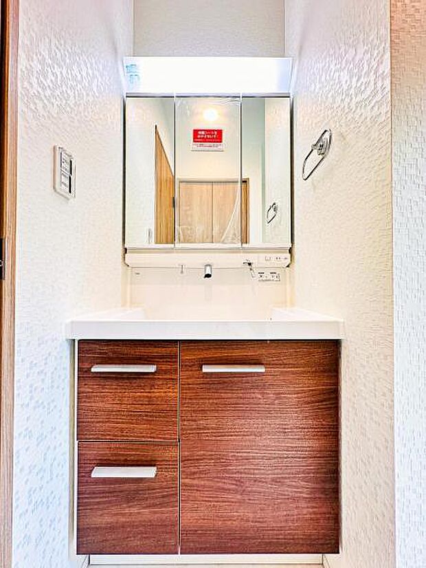 【収納豊富な三面鏡洗面台】左右の鏡を開いて三面鏡としても使える大型の鏡を設置。鏡の裏には、洗面用具などを機能的に収納できるスペースを設けています。