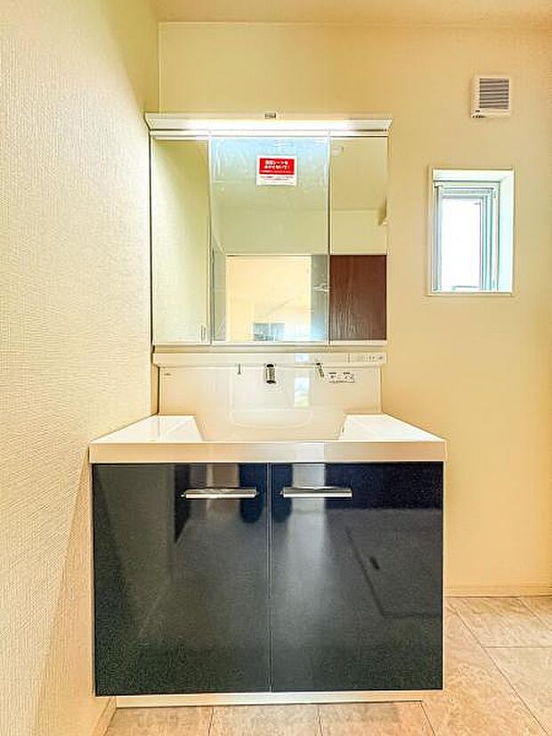 【嬉しい収納豊富な三面鏡洗面台】左右の鏡を開いて三面鏡としても使える大型の鏡を設置。鏡の裏には、洗面用具などを機能的に収納できるスペースを設けています。