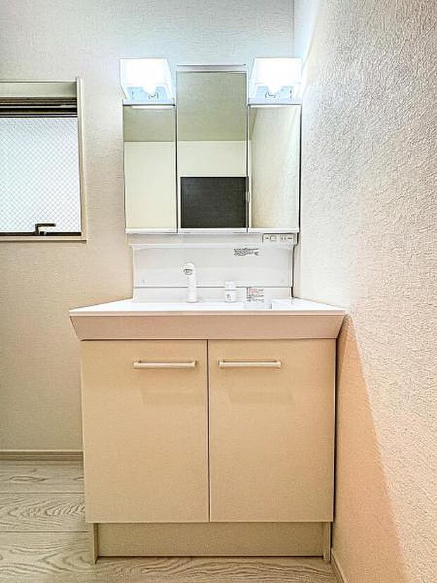 【嬉しい収納豊富な三面鏡洗面台】左右の鏡を開いて三面鏡としても使える大型の鏡を設置。鏡の裏には、洗面用具などを機能的に収納できるスペースを設けています。