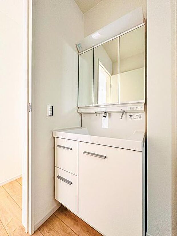 【収納豊富な三面鏡洗面台】左右の鏡を開いて三面鏡としても使える大型の鏡を設置。鏡の裏には、洗面用具などを機能的に収納できるスペースを設けています。