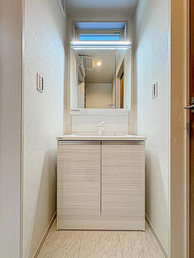 【嬉しい収納豊富な三面鏡洗面台】左右の鏡を開いて三面鏡としても使える大型の鏡を設置。鏡の裏には、洗面用具などを機能的に収納できるスペースを設けています。