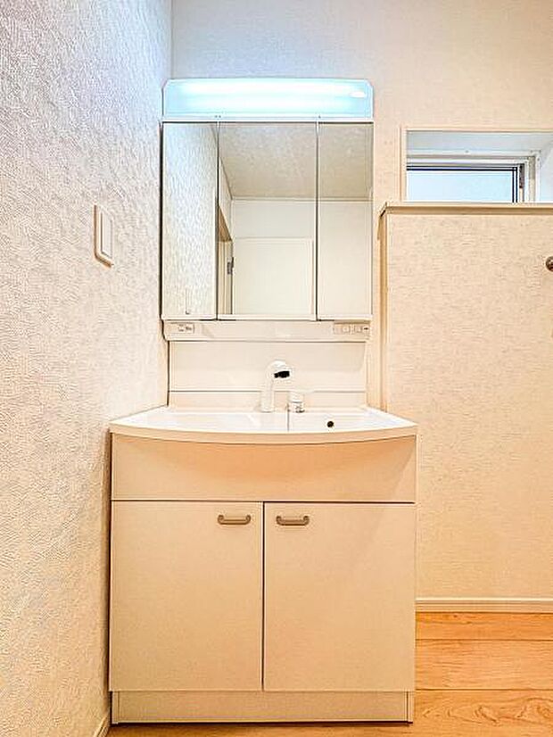 【嬉しい収納豊富な三面鏡洗面台】左右の鏡を開いて三面鏡としても使える大型の鏡を設置。鏡の裏には、洗面用具などを機能的に収納できるスペースを設けています。