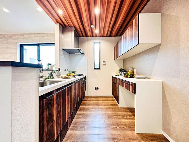 【リビングを見渡せる開放感のある対面式キッチン】キッチン背面にキッチンと同色の面材を使用したカップボードを設置し収納力と統一感を高めています。散らかりがちなキッチン周りをスッキリまとめられます。