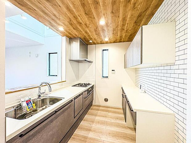 【リビングを見渡せる開放感のある対面式キッチン】キッチン背面にキッチンと同色の面材を使用したカップボードを設置し収納力と統一感を高めています。散らかりがちなキッチン周りをスッキリまとめられます。