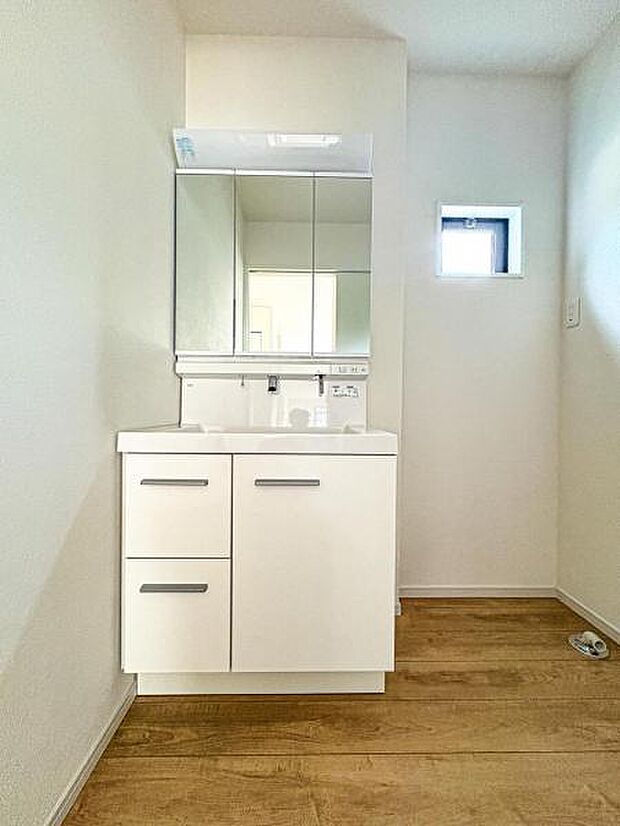 【嬉しい収納豊富な三面鏡洗面台】左右の鏡を開いて三面鏡としても使える大型の鏡を設置。鏡の裏には、洗面用具などを機能的に収納できるスペースを設けています。