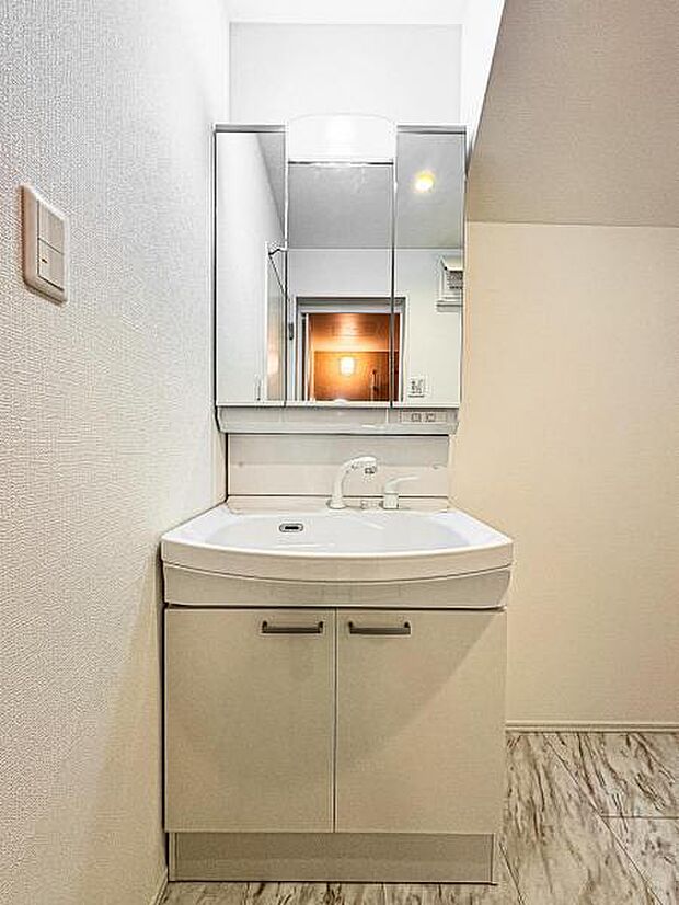 【嬉しい収納豊富な三面鏡洗面台】左右の鏡を開いて三面鏡としても使える大型の鏡を設置。鏡の裏には、洗面用具などを機能的に収納できるスペースを設けています。