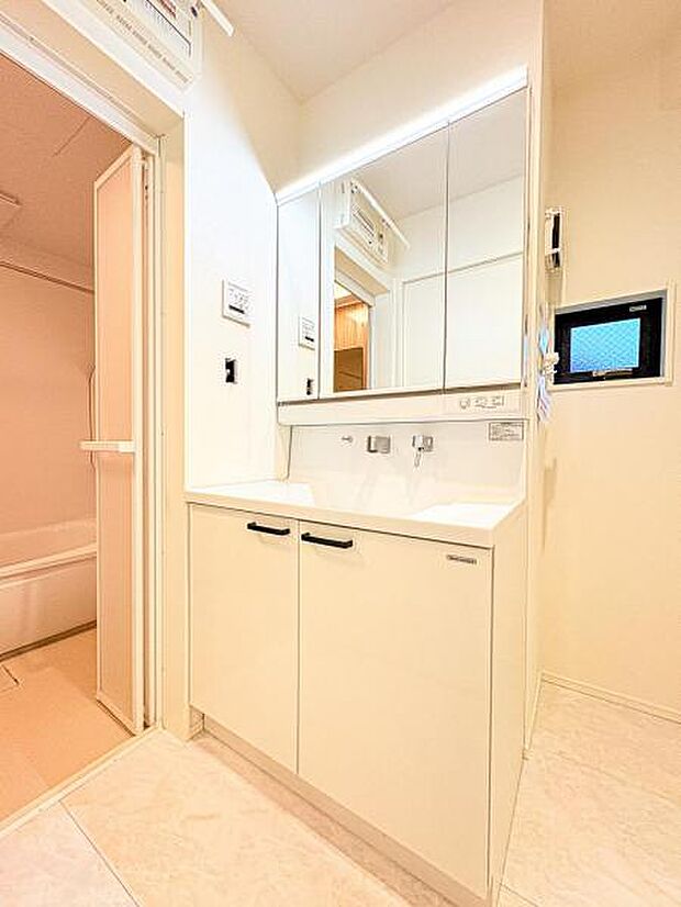 【収納豊富な三面鏡洗面台】左右の鏡を開いて三面鏡としても使える大型の鏡を設置。鏡の裏には、洗面用具などを機能的に収納できるスペースを設けています。