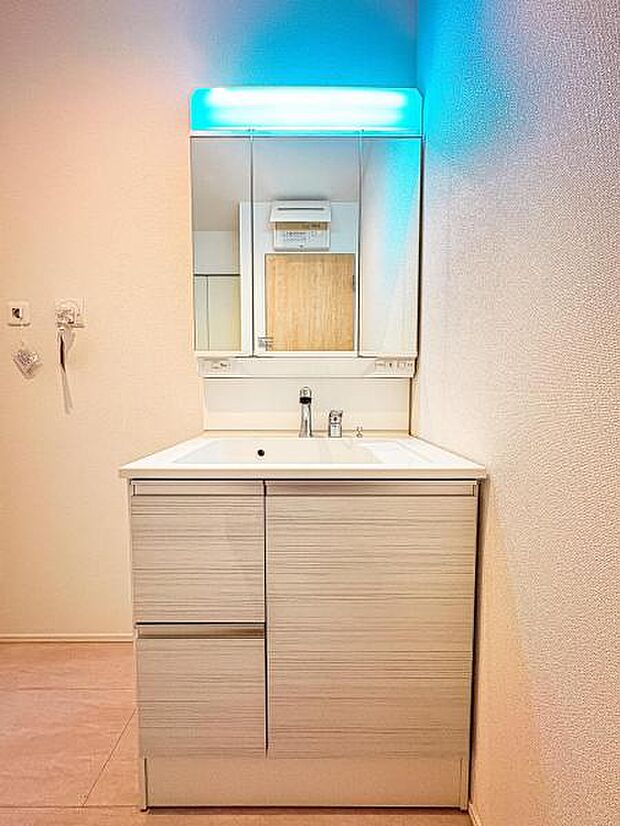 【嬉しい収納豊富な三面鏡洗面台】左右の鏡を開いて三面鏡としても使える大型の鏡を設置。鏡の裏には、洗面用具などを機能的に収納できるスペースを設けています。