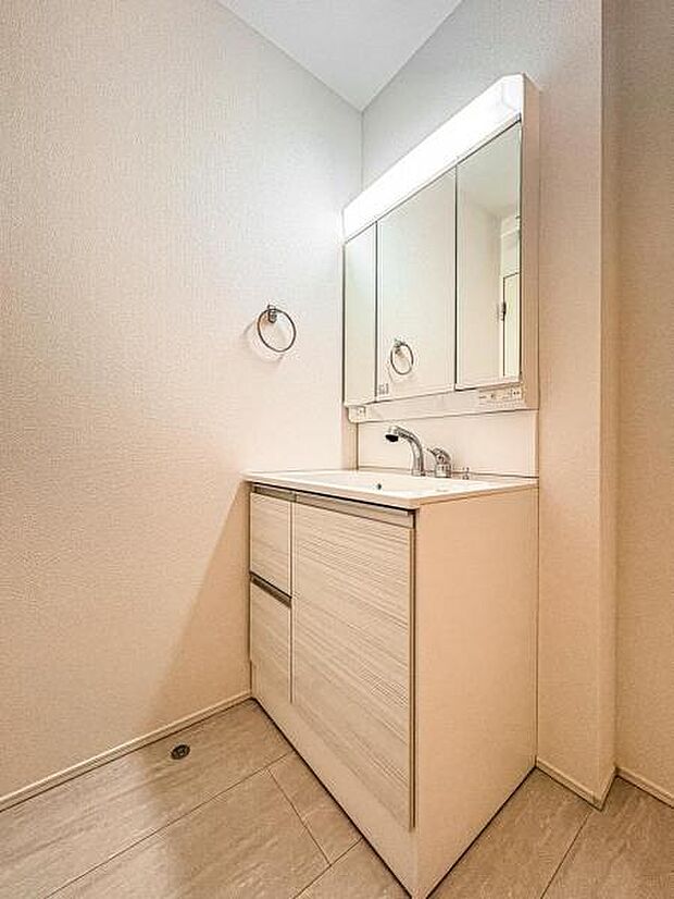 【嬉しい収納豊富な三面鏡洗面台】左右の鏡を開いて三面鏡としても使える大型の鏡を設置。鏡の裏には、洗面用具などを機能的に収納できるスペースを設けています。