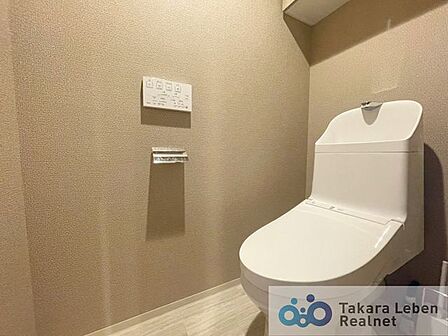 ウォシュレット機能付きのトイレは壁掛けリモコンの上位グレードを採用。便座がスッキリした印象となり、限られた空間を広く見せる効果があります。