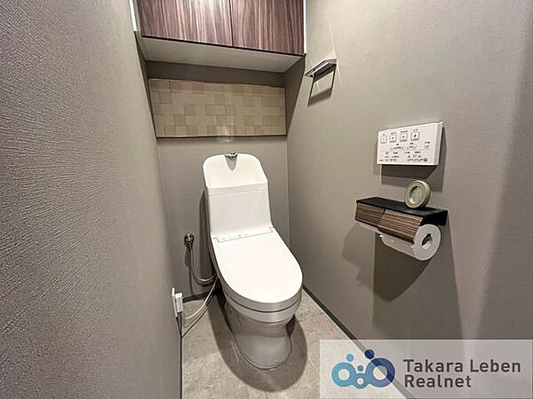 ウォシュレット機能付きのトイレは壁掛けリモコンの上位グレードを採用。便座がスッキリした印象となり、限られた空間を広く見せる効果があります。