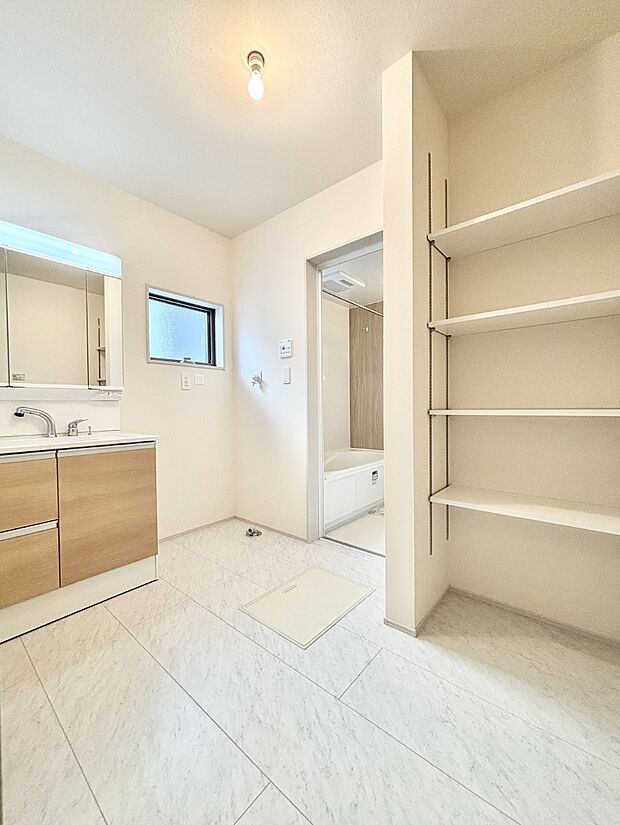 タオルや洗面用具のストック類を置ける便利な可動棚つきの脱衣場。