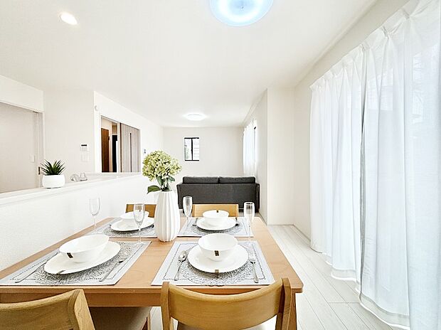 明るい陽光が注ぎ、寛ぎの雰囲気に満たされるリビング・ダイニング。 