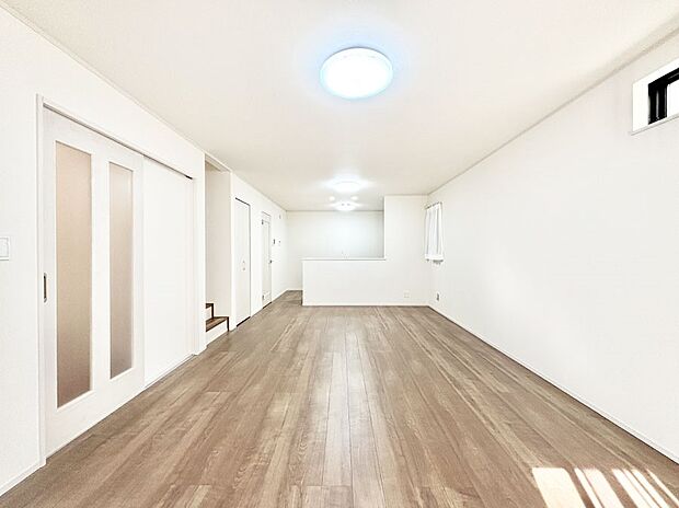 明るい陽光が注ぎ、寛ぎの雰囲気に満たされるリビング・ダイニング。 