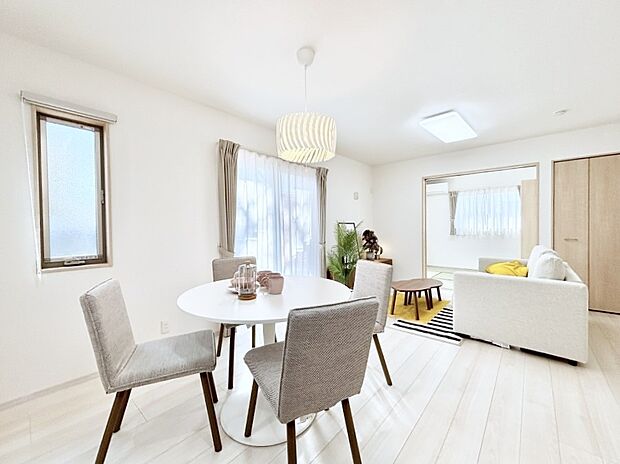 明るい陽光が注ぎ、寛ぎの雰囲気に満たされるリビング・ダイニング。 