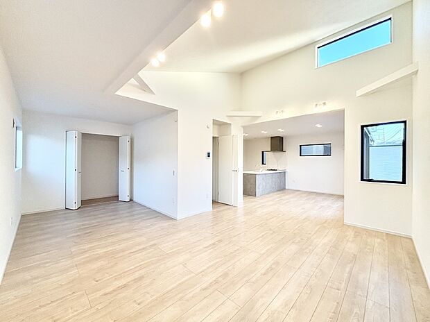 吹き抜けから明るい陽光が注ぎ、寛ぎの雰囲気に満たされるダイニング。