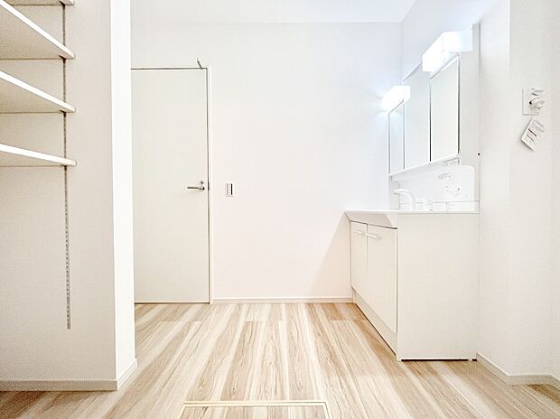 タオルや洗面用具のストック類を置ける便利な可動棚つきの脱衣場。