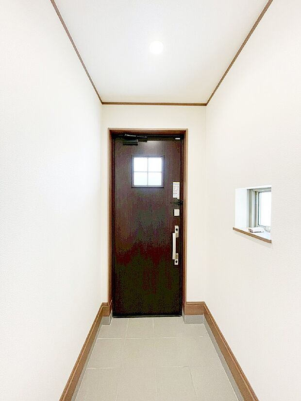 小窓から陽光を感じられる玄関