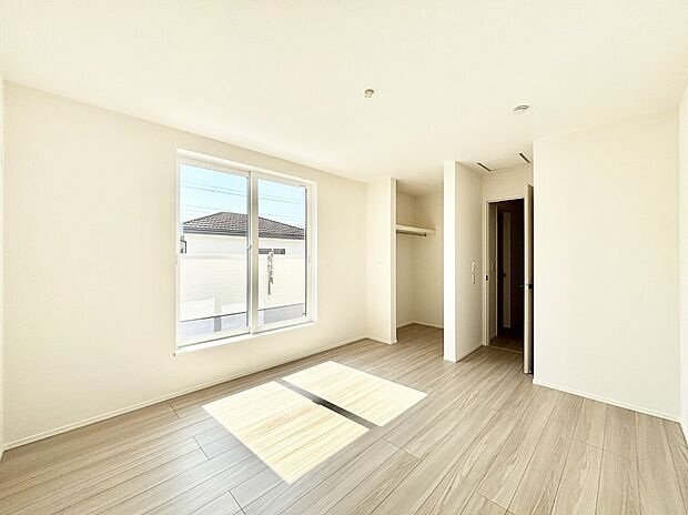 WIC付きの洋室。バルコニーから入る明るい陽光が部屋全体を明るく照らします。