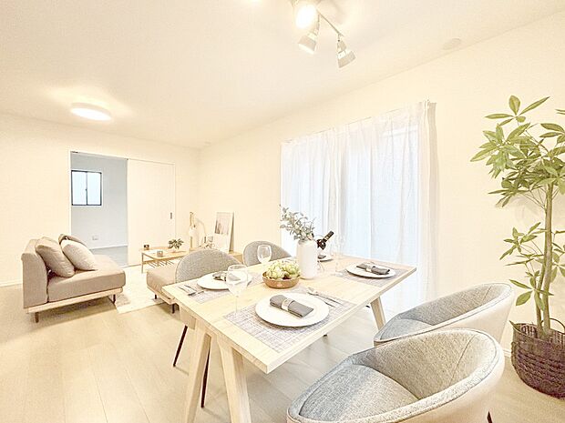 明るい陽光が注ぎ、寛ぎの雰囲気に満たされるリビング・ダイニング。 