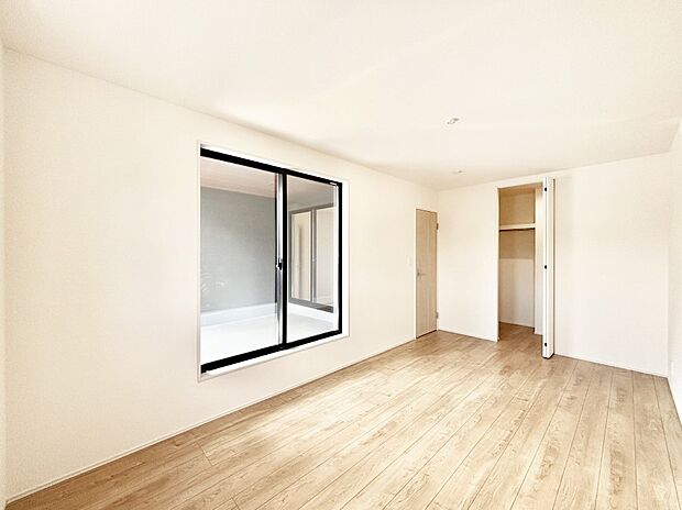 WIC付きの洋室。バルコニーから入る明るい陽光が部屋全体を明るく照らします。
