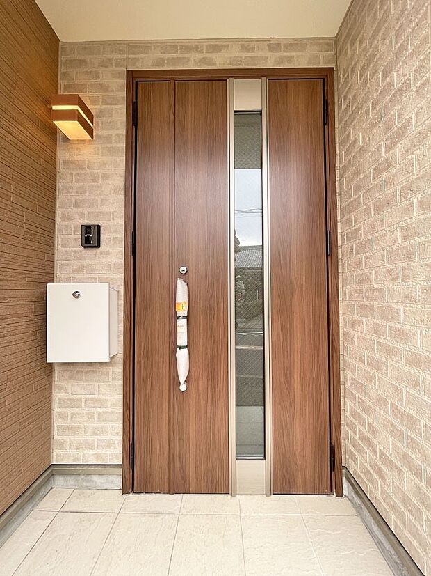 木の温もりが感じられるシンプルな玄関ドアがお迎えします