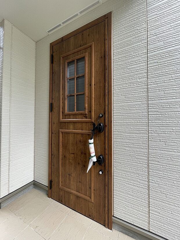 木の温もりが感じられるシンプルな玄関ドアがお迎えします