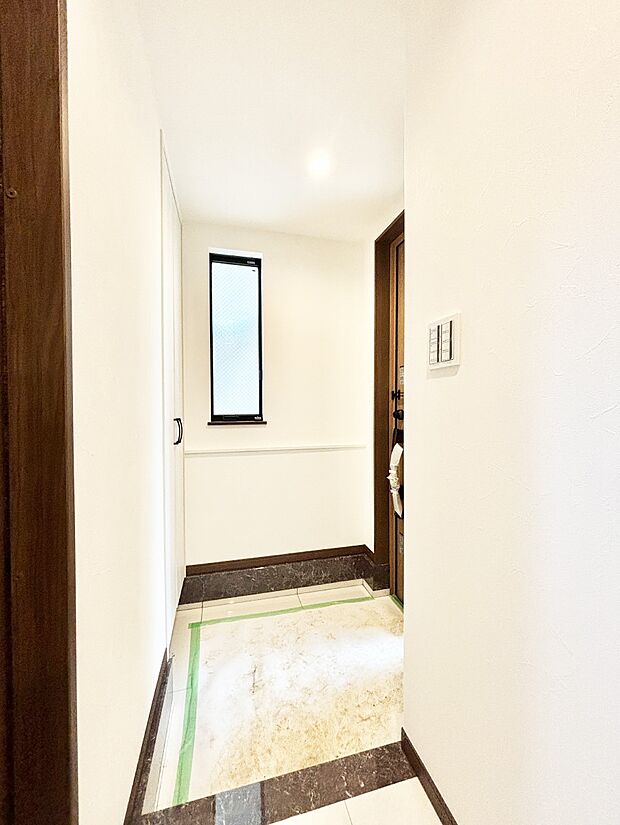 小窓から陽光を感じられる明るい玄関
