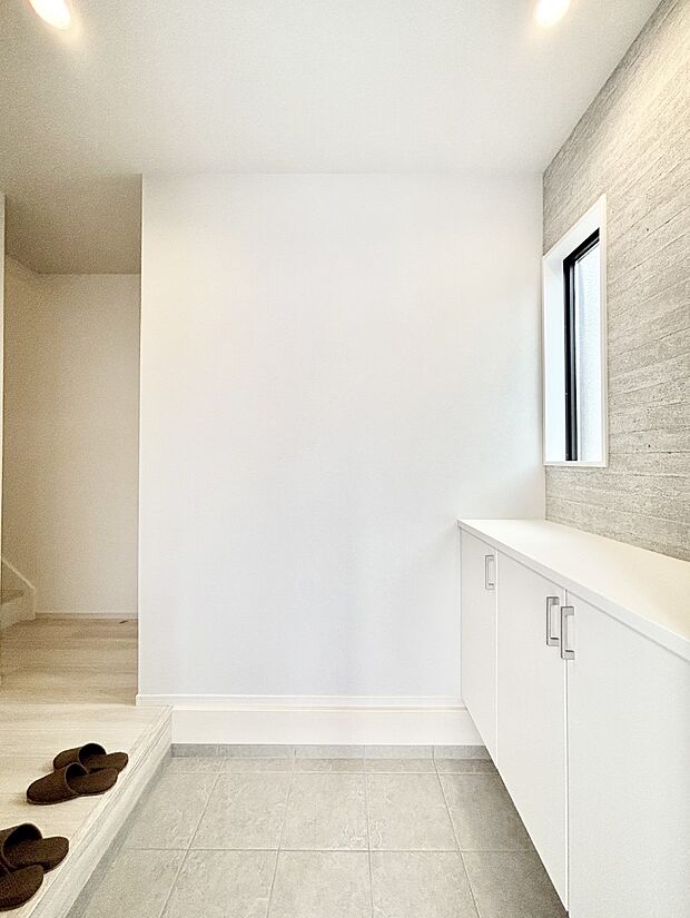 小窓から陽光を感じられる明るい玄関