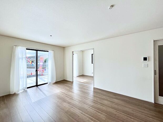 明るい陽光が注ぎ、寛ぎの雰囲気に満たされるリビング・ダイニング。 