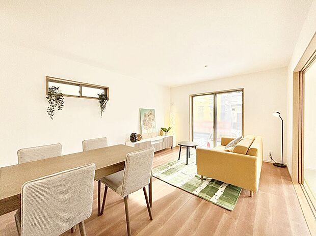 明るい陽光が注ぎ、寛ぎの雰囲気に満たされるリビング・ダイニング。 