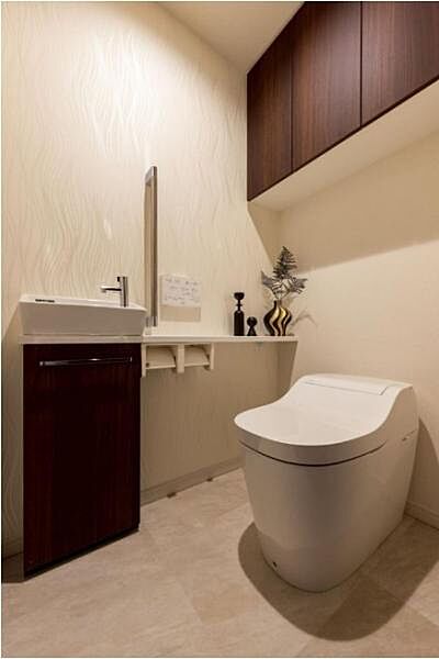 ～トイレ～ 上部に吊戸棚が設置された温水洗浄機能のトイレです。