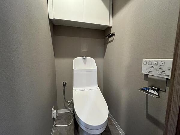 ～トイレ～ 上部に吊戸棚が設置された温水洗浄機能付のトイレです。