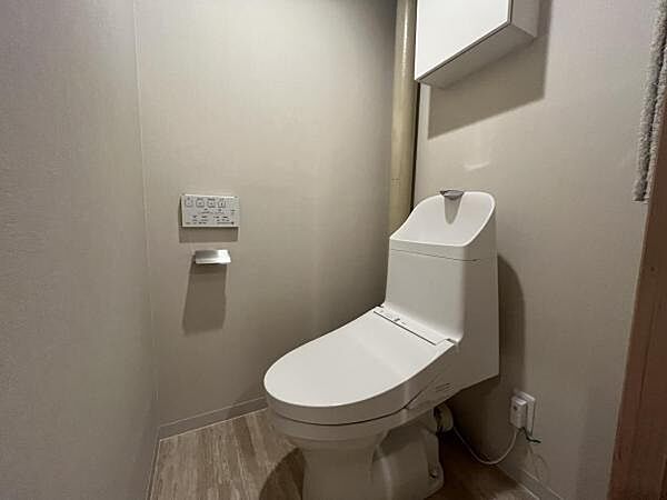 ～トイレ～ 上部に吊戸棚が設置された温水洗浄機能のトイレです。
