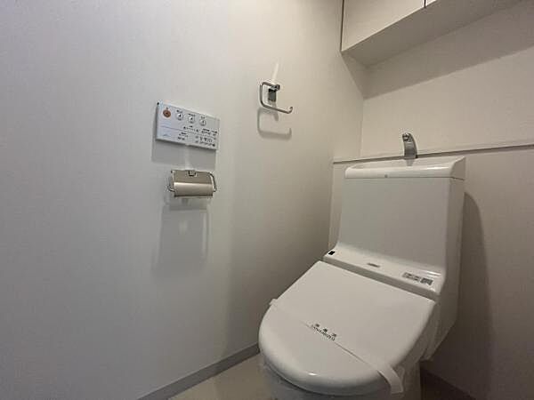 ～トイレ～ 上部に吊戸棚が設置された温水洗浄機能付トイレです。