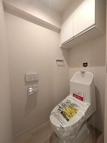 洗浄便座のトイレ、吊戸棚にトイレ用品をしまっていただけます