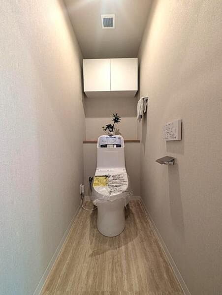洗浄便座のトイレを新設、吊戸棚がありトイレ用品の収納にも便利