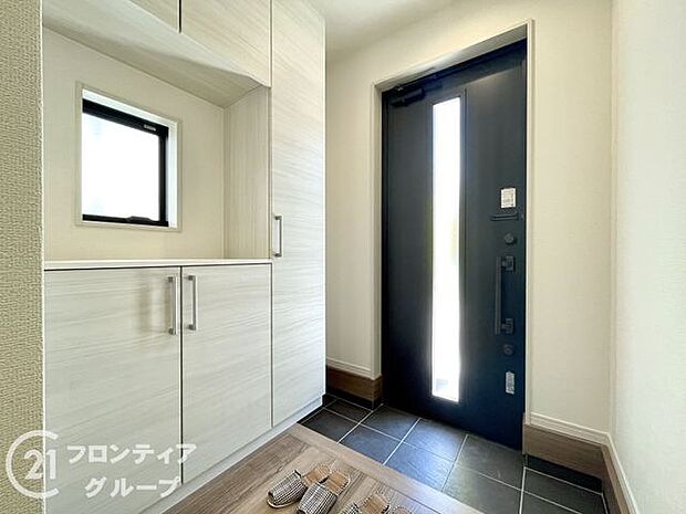 外観に調和したデザインの玄関は、温かみのある雰囲気を醸し出します。美しいドアとシンプルなラインが、家の印象を引き立て、来客を迎えるにふさわしい洗練された空間で、心地よい第一印象を与えます。