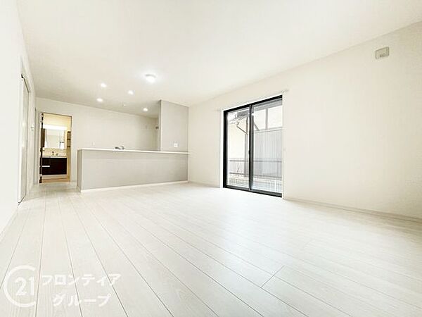 木目の温もりを感じるフローリングと白い壁が調和した、明るく開放感のあるリビングです。大きな窓からは心地よい光が差し込み、家族が集まる憩いの場所として相応しいゆとりの広さを確保しています
